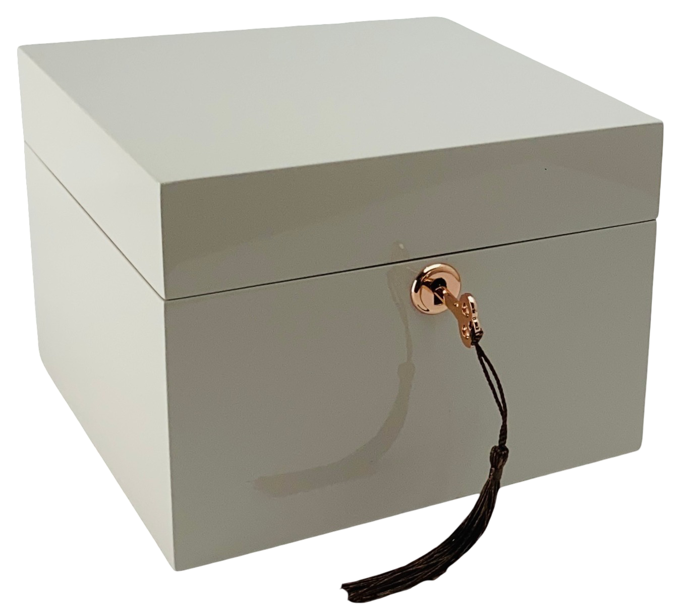 taupe jewelry box with a gold clasp and black tassel on a white background